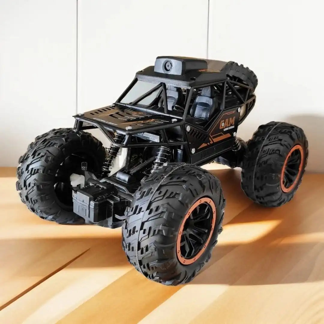 Toy monster truck with large wheels  on floor surface with cam on its roof