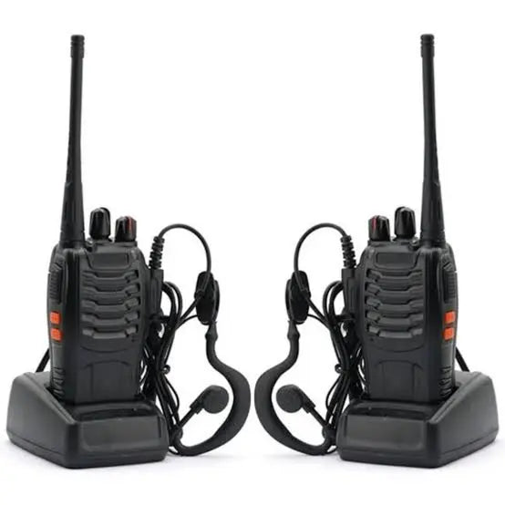 A set of two Baofeng BF-888S portable walkie talkies docked in their charging bases with connected hands-free earpiece headsets, available at Lebtech Store with fast delivery across Lebanon.