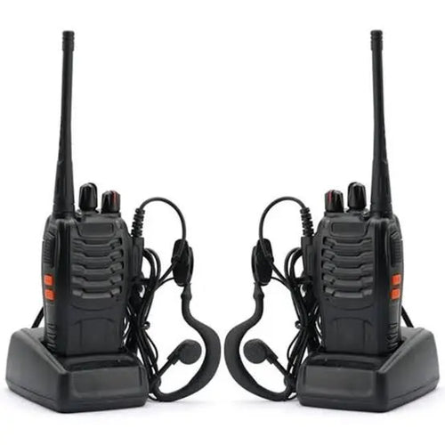 A set of two Baofeng BF-888S portable walkie talkies docked in their charging bases with connected hands-free earpiece