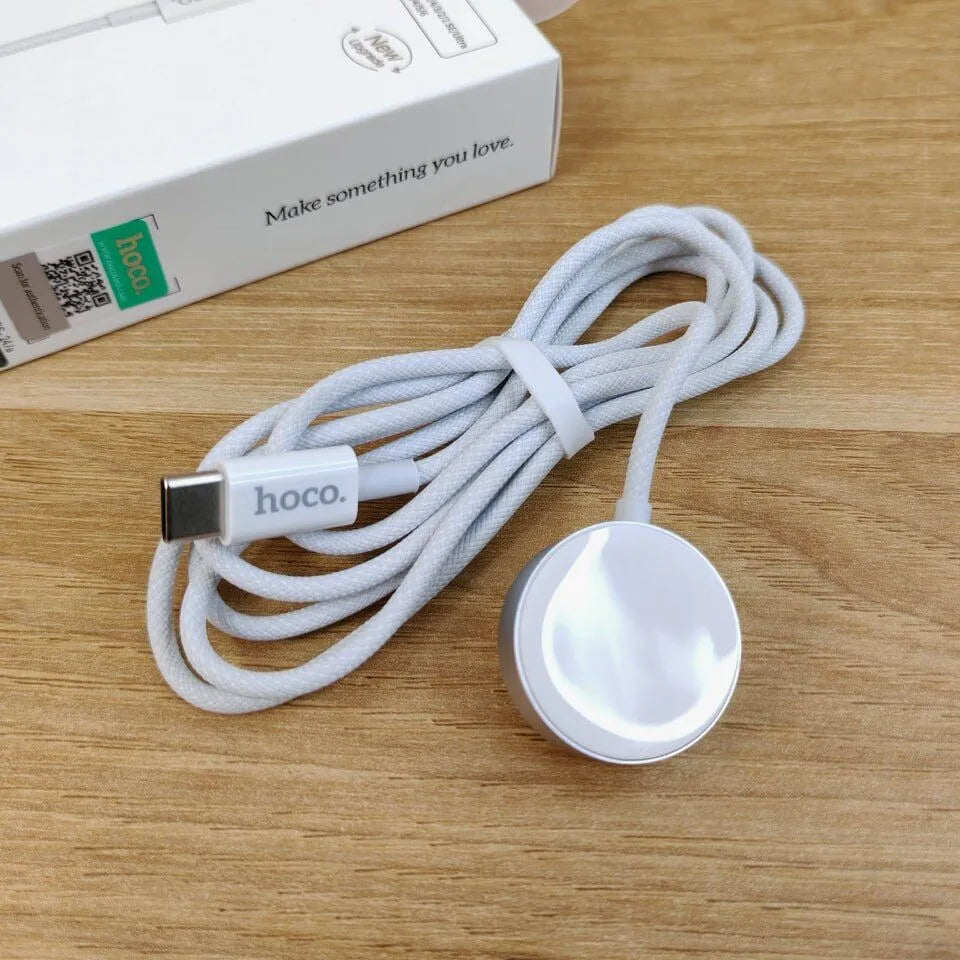 White USB cable with 'hoco.' branding on a wooden surface, next to a white box.
