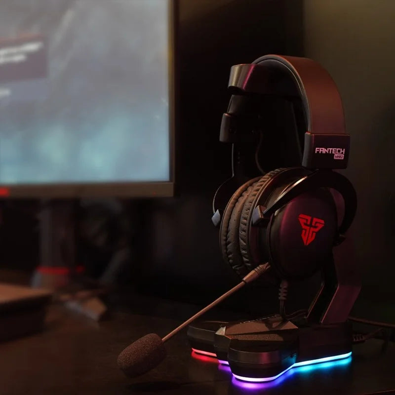 Gaming headset with microphone on a stand in front of a computer screen