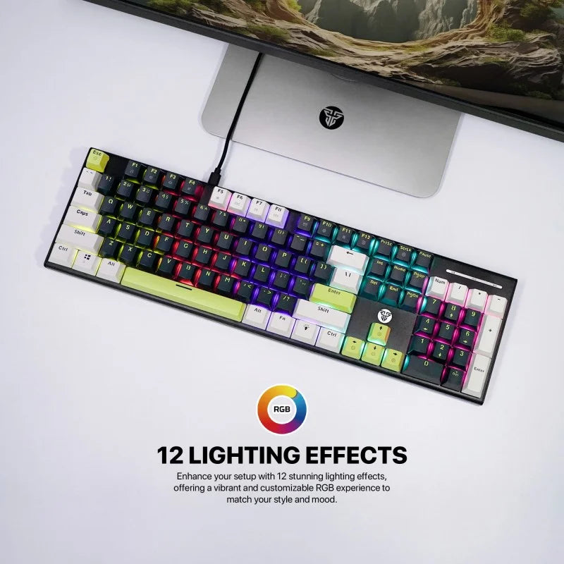 Keyboard with RGB lighting effects in front of a computer monitor on a white surface.