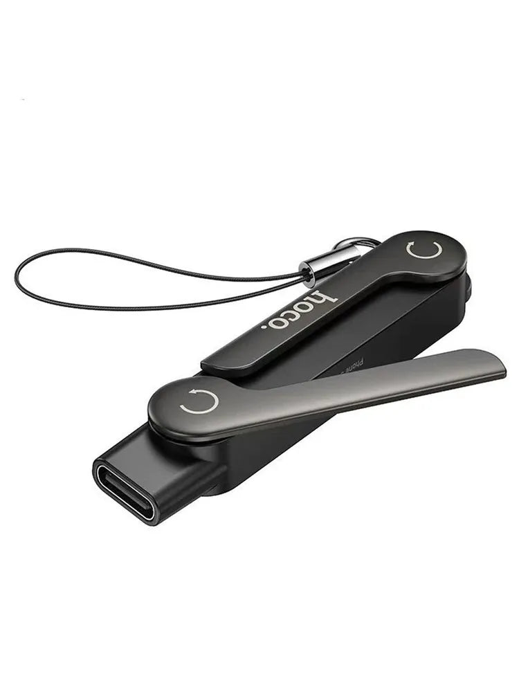 Hoco UA47A Type-C 2-in-1 charging adapter and phone stand showing the black zinc alloy body with its anti-loss lanyard strap and the integrated leg extended outward, available at Lebtech Store with fast delivery across Lebanon.
