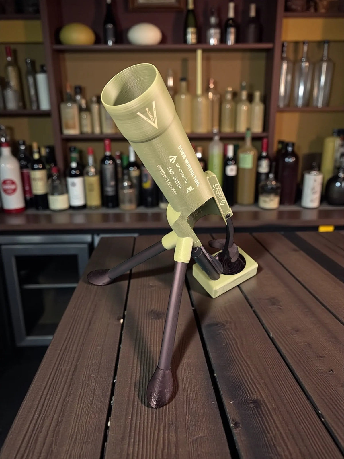 Lebtech Mini Mortar Cannon Beer Cap Launcher Opener displayed on a rustic wooden bar counter from Lebtech Store Lebanon