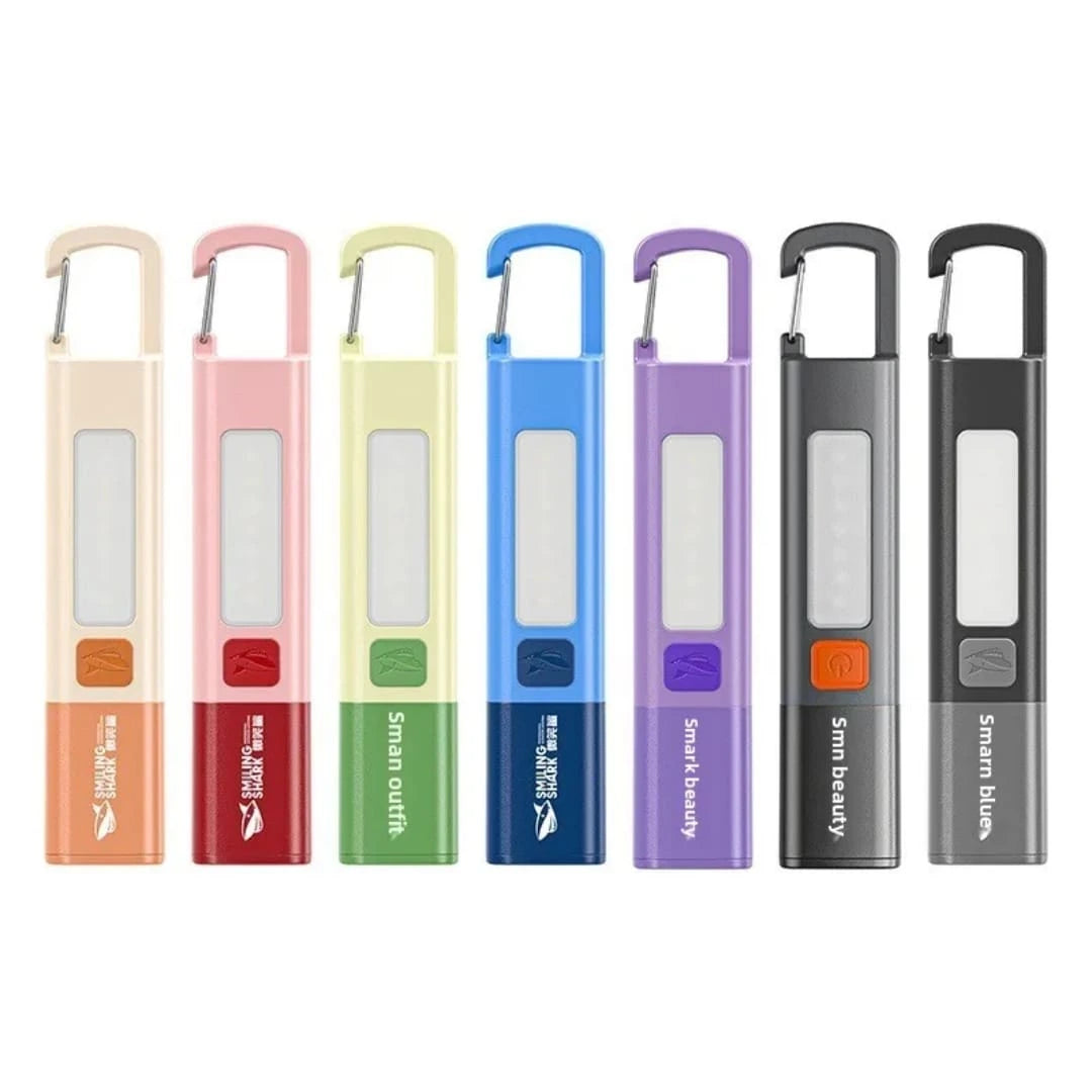 Multi-color lineup of Smiling Shark mini handheld LED pocket flashlights showing the integrated carabiner lock buckle clips from LebTech Store Lebanon.